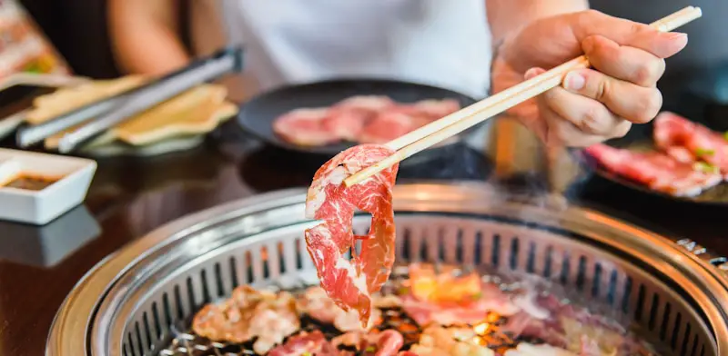 womans hand with chop sticks bbq